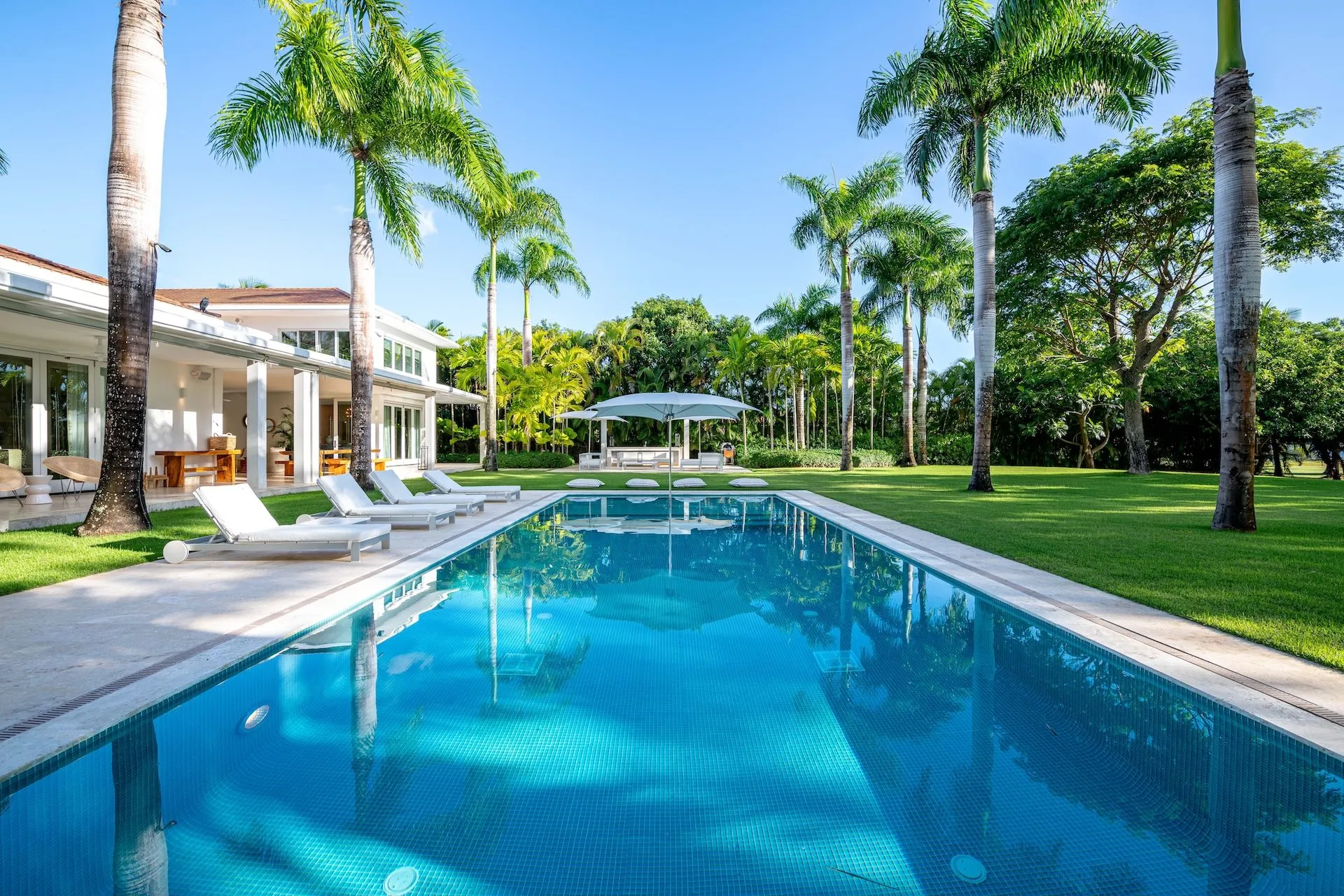 Lap pool with royal palms and tropical garden at Villa Las Palmas 11, Casa de Campo La Romana