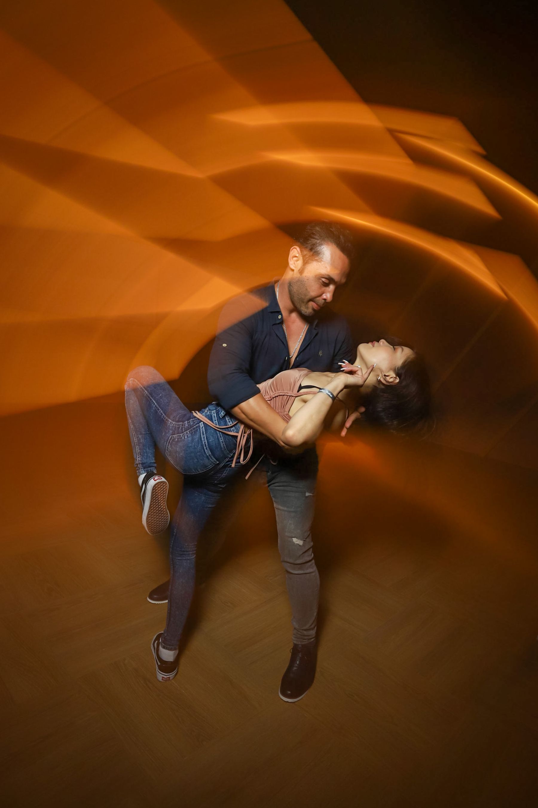 A couple dancing under warm stage light